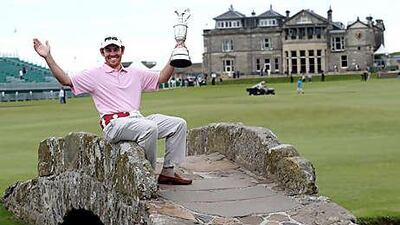 Louis Oosthuizen holds the Claret Jug on the Swilken Bridge at St Andrews yesterday.