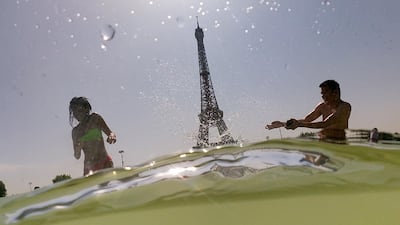 People cool off at the Trocadero Fountains next to the Eiffel Tower in Paris. AFP