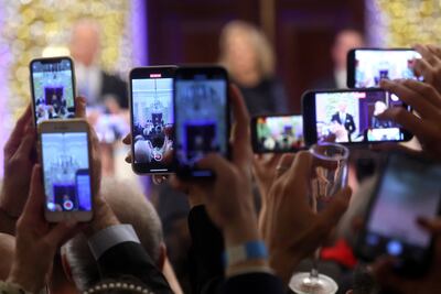 Audience members record on their phones as US President Joe Biden and first lady Jill Biden host a Hanukkah holiday reception at the White House in Washington, on December 19. Reuters
