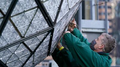 Workers from Landmark Signs install a panel of Waterford crystal triangles on the Times Square New Year's Eve ball. AP