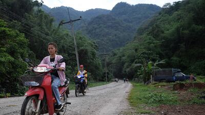 Motorists along the road from the Tham Luang cave, in which 12 boys from the "Wild Boars" football team and their coach were trapped last year, in the Mae Sai district of Chiang Rai province. AFP