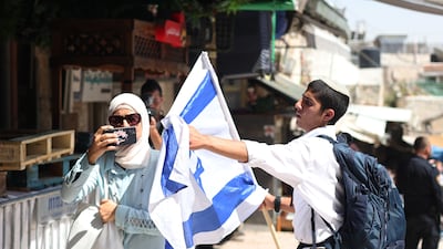 A Flag March participant tries to stop a woman taking photos. EPA