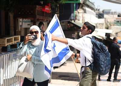 An Israeli tries to prevent a woman from taking photos in the Old City of Jerusalem on 5 June 2024, as Israel marks the capture of the city in 1967. Policing for Israelis and Palestinians varies wildly. EPA