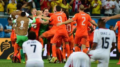 Netherlands players begin to celebrate as Costa Rica players, near, react after Netherlands defeat Costa Rica in a penalty shootout on Saturday in the 2014 World Cup quarter-finals. Ronaldo Schemidt / AFP
