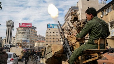 A Syrian rebel fighter fires rounds as people celebrate in Homs after the city's liberation from the stranglehold of the Assad regime. AFP
