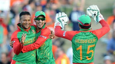 Bangladesh bowler Shakib Al Hasan, left, is congratulated by teammates Nasir Hossain and Mushfiqur Rahim, right, after taking the wicket. (AP Photo/Ross Setford)