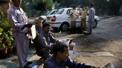 Taxi drivers read newspapers as they wait for business at the Defence Colony market in New Delhi.