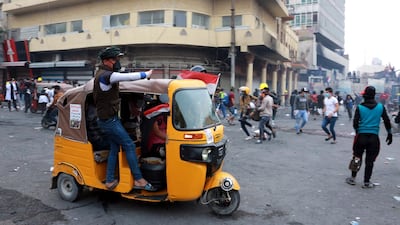 Iraqi protesters react after police fired tear gas at them during a demonstration at Al-Rasheed street in central Baghdad. EPA