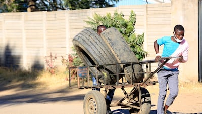 A man pulls a cart with used vehicle tyres for resale in an industrial area in Harare, Zimbabwe. The Zimbabwean government has tightened screws on the lockdown soon after rising Covid infections. EPA