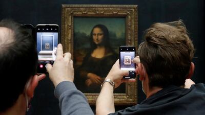 Visitors take pictures of the painting 'Mona Lisa' on the first day after the Louvre in Paris reopens. Reuters