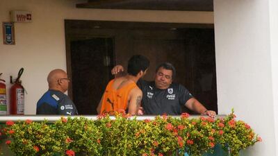 Uruguay’s Luis Suarez is seen embracing a member of the coaching staff on a balcony at the team’s hotel in Natal, June 26, 2014. Suarez was hit with the biggest ban imposed at a World Cup on Thursday as FIFA threw the book at one of soccer’s most talented but controversial players for biting an opponent during the 2014 World Cup match against Italy. REUTERS/Leo Carioca