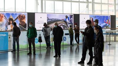 People wearing protective masks watch a television screen displaying a broadcast of a news report featuring North Korean leader Kim Jong Un at Seoul Station in Seoul, South Korea, on Tuesday, April 21, 2020. Bloomberg