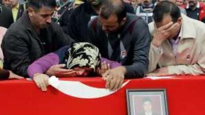 Family members react over the flag-draped coffin of Hasan Aygor, one of 15 Turkish soldiers killed Friday by Kurdish rebels at Turkey-Iraq border.
