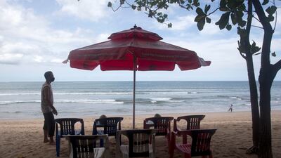 A beach vendor sets chairs as he waits for customers in Kuta beach in Bali, Indonesia. AP Photo