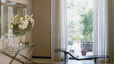 Stylish seating in front of window with full length curtains in modern sitting room.