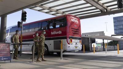 Army personnel watch as a charter bus that unloaded crew from the Ruby Princess Cruise ship departs Sydney Airport in Sydney, Australia. Getty