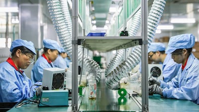 Employees assemble electric car charging components at a factory in Ruichang, central China. AFP