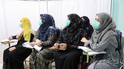 Women are separated from male students by a partition. EPA