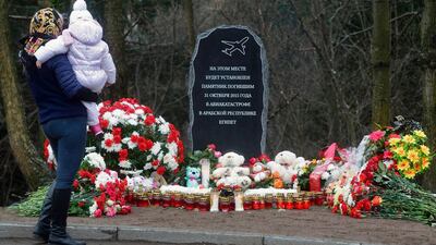 In the town of Vsevolozhsk outside Saint Petersburg on October 31, 2016, a woman with a baby is mourning in front of the foundation stone for a Garden of Memory commemorating the 224 people killed in the bombing of a Russian airliner over Egypt one year ago. Olga Maltseva/AFP