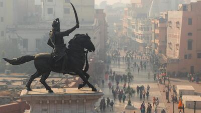 People near the statue of Maharaja Ranjit Singh along Heritage Street under heavy smog conditions in Amritsar. AFP