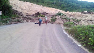 Locals inspect a landslide and damage to a road located near the township of Tabubil after an earthquake that struck Papua New Guinea's Southern Highlands, on February 26, 2018. Jerome Kay / Handout via Reuters