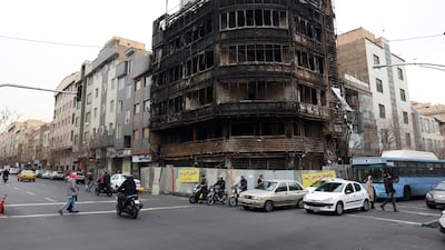 Iranians drive past a branch of Bank Melli Iran which was burnt during anti-government protests in Tehran, Iran, 19 January 2026. EPA