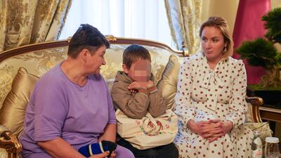 A Ukrainian boy, 7, one of those being repatriated, is seated next to his grandmother, left, and Russia's children's rights commissioner Maria Lvova-Belova. Reuters