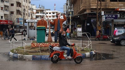 A man gestures as he commutes in the Syrian town of Jableh, north-west of the capital Damascus, on Saturday. AFP