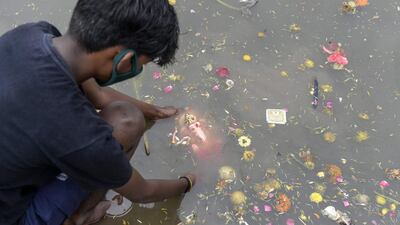 A devotee immerses a clay idol of Hindu elephant-headed deity Ganesh in an artificial tank on the fifth day of the Ganesh Chaturthi festival, in Hyderabad. AFP