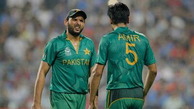 Pakistan's Shahid Afridi, left, talks to Mohammad Amir during the ICC World Twenty20 2016 cricket match against India at Eden Gardens in Kolkata, India, Saturday, March 19, 2016. (AP Photo/ Bikas Das)