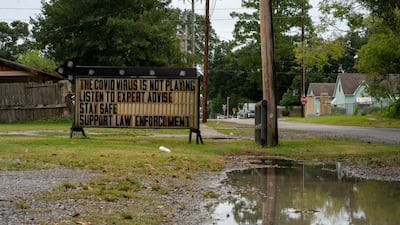 A sign advising on Covid-19 and law enforcement is seen as Hurricane Laura approaches Abbeville, Louisiana, US. Reuters