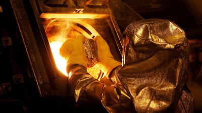 A refinery technician puts a gold 'button' into a furnace at Newmont Mining's Carlin gold mine operation in the US. The precious metal is often considered a safe haven by investors in troubled financial times. Photo: Reuters
