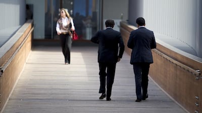 Businessmen and a businesswoman walk across a bridge in Dubai (Photo by: Sarah Dea/ The National)