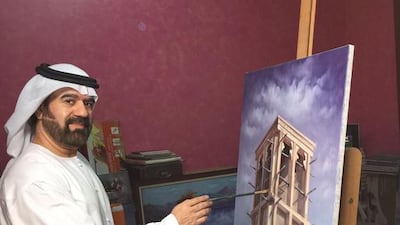 Faisal Abdulqader with one of his oil paintings inspired by scenes of traditional Emirati life in Dubai. Courtesy Faisal Abdulqader