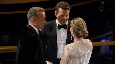 Tom Hanks, from left, Bradley Cooper and Rita Wilson speak in the audience at the Oscars. AP