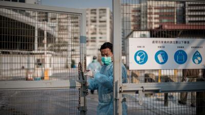 A security guard closes the gate of a live poultry market in Cheung Sha Wan before officials proceed to cull chickens. Philippe Lopez / AFP Photo