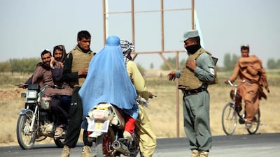 Afghan security officials stand guard on a checkpoint on Helmand-Kandahar highway after Taliban launched first large-scale attack on the capital of southwestern Helmand province in Afghanistan since the signing of a peace deal with the United States. EPA