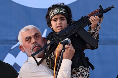 Hamas leader Yahya Sinwar holds the child of an Ezzedine Al Qassam Brigades fighter in 2021. AFP