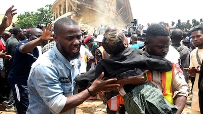 Rescuers take a pupil from the rubble of the Saints Academy college in northern Nigeria. AP