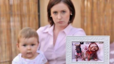 Bella Stevenson shows a picture of her daughter,Silver, when she was younger with their dogs Vinnie(L), a minature pinscher, and Leo, a toy poodle, which were both attacked and killed by a doberman pinscher on Mondaynight, Dec. 03, 2012 just outside the home of the Steveson's in Jumeriah Village Triangle. The picture was taken on Thursday, Dec.06, 2012 at their home in Jumeriah Village, Dubai, United Arab Emirates.