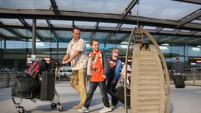 Dale, Andrew, and James Anderton, from Eastbourne, look at the sculpture of the Burj Al Arab at London Gatwick Airport. Matt Alexander / PA