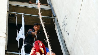 Iraqi demonstrators use blankets to supply food to their fellows inside the high-rise building. REUTERS