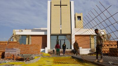 Construction workers carry out cement work on the outer courtyard of the 'Ibrahim Al-Khalil' church, in Iraq. Reuters