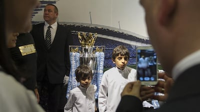 Two young Emirati Manchester City fans get their picture taken with the Premier League trophy, which was on hand for a player appearance at Marina Mall in Abu Dhabi on Tuesday. Mona Al-Marzooqi / The National / May 13, 2014