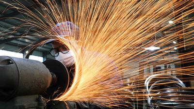 A worker wearing a face mask works on a production line manufacturing bicycle steel rims in China's Hangzhou, Zhejiang province. Factory output levels and new orders are recovering in the world's second largest economy. Reuters
