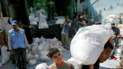 Palestinians unload sacks of food from a United Nations Relief and Works Agency lorry.