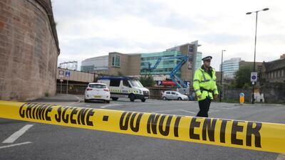 A policeman stands behind a cordon area near the Manchester Arena, where at least 22 people were killed in a suicide bombing.