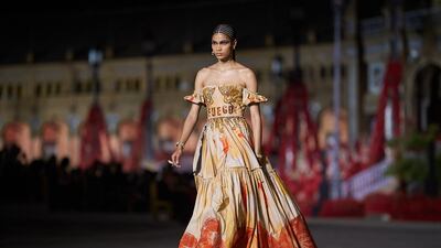 A model wears a dress decorated with "fuego", the Spanish word for fire, written on the waistband. Getty Images