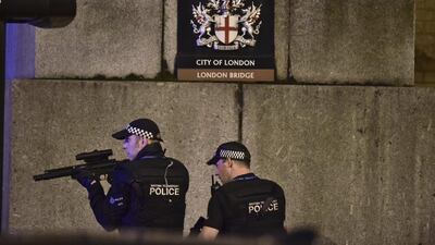 An armed Police officer looks through his weapon on London Bridge. Dominic Lipinski / PA via AP