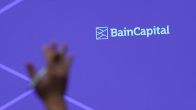 A reporter raises his hand to ask a question during a news conference by Bain Capital. The company has $105bn of assets under management, according to its website. Reuters